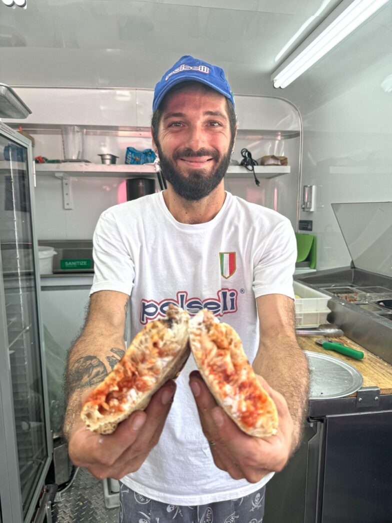 a man holding two slices of pizza in his hands