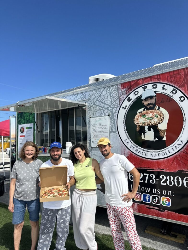 a group of people standing in front of a food truck