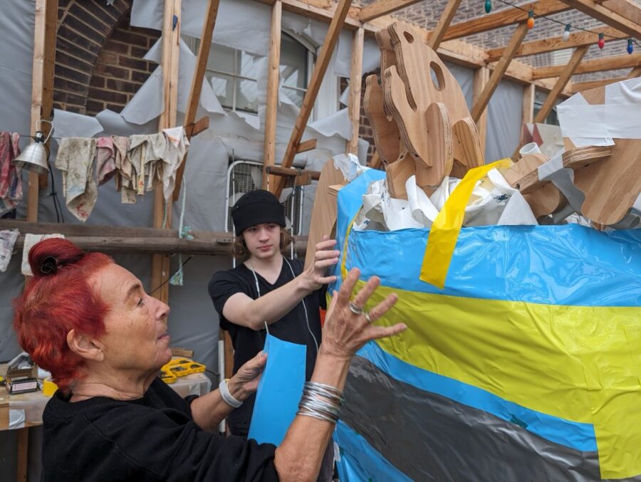 a group of people standing around a pile of clothes