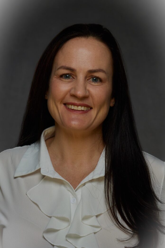 a woman in a white shirt smiling at the camera
