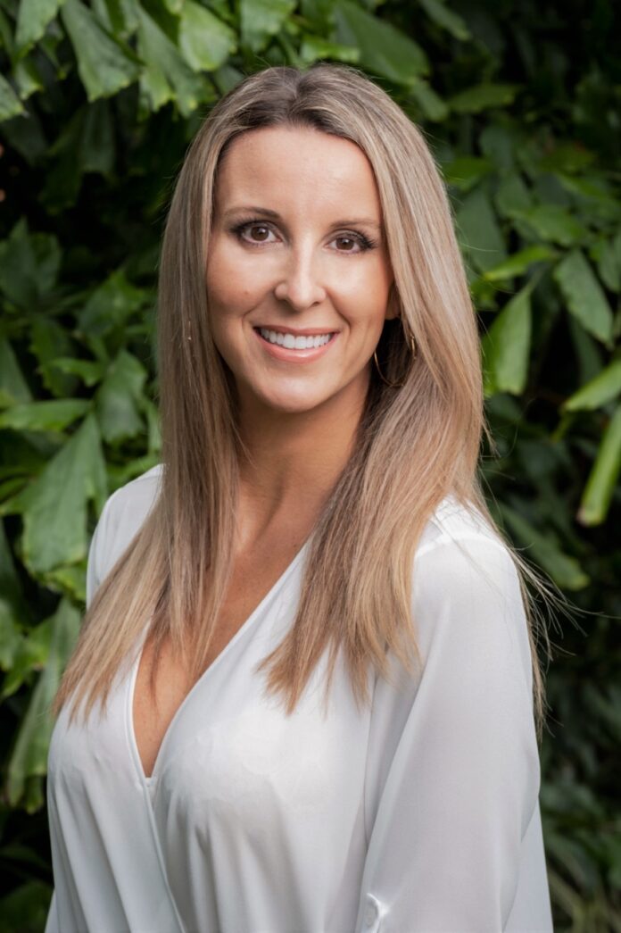 a woman standing in front of a bush