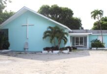 a blue church with palm trees in front of it