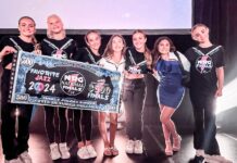 a group of people standing on a stage holding a large check