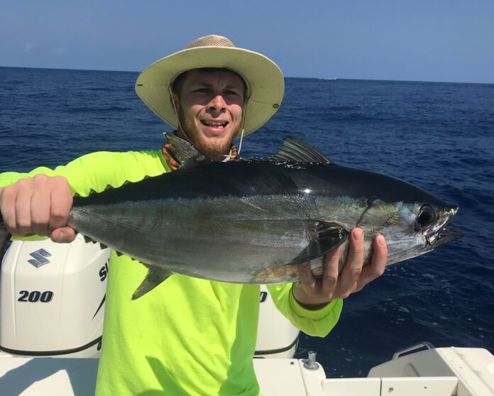 a man on a boat holding a fish