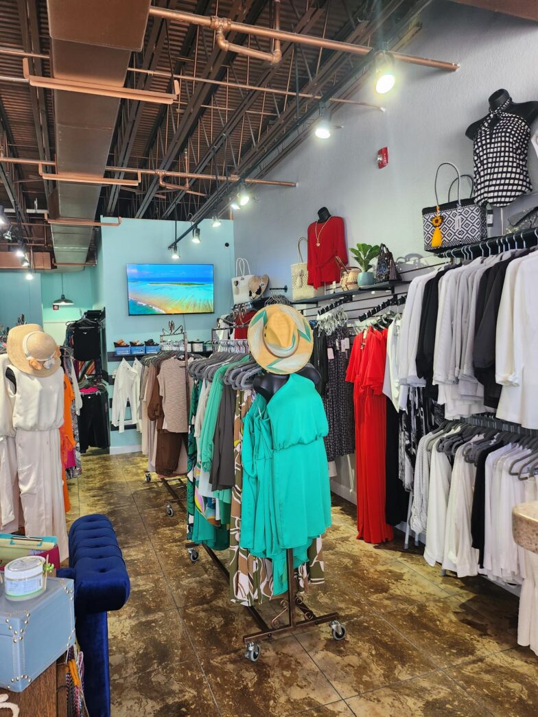 a room filled with lots of clothes hanging from the ceiling