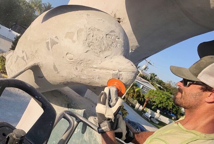 a man sitting in a truck working on a sculpture