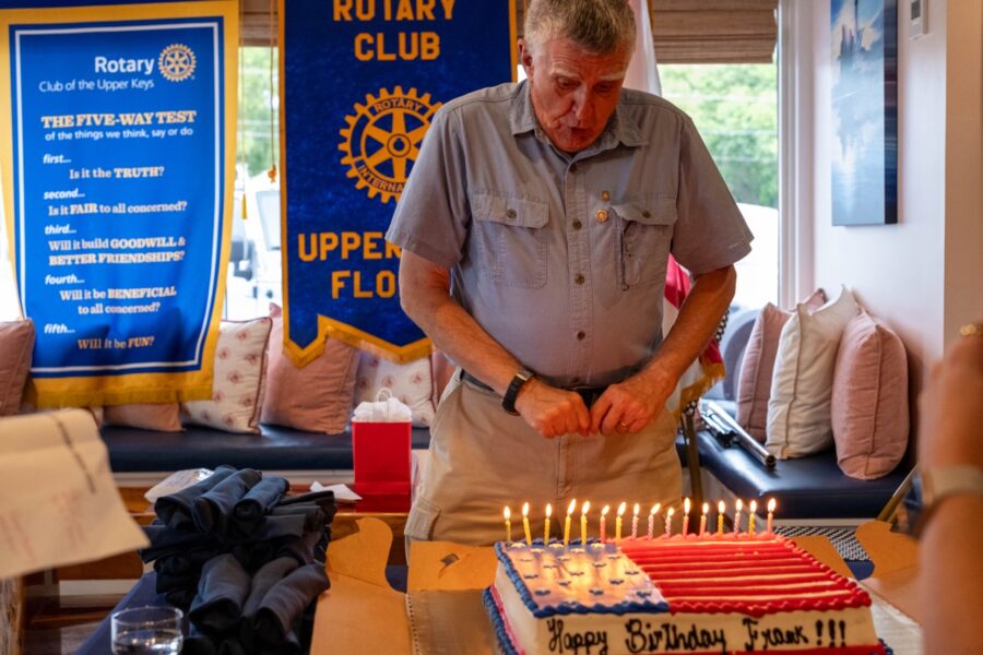 a man standing in front of a table with a cake on it