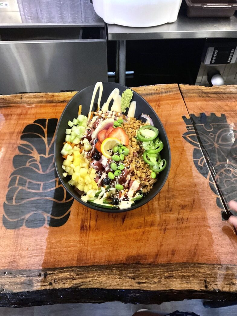 a bowl of food sitting on top of a wooden table