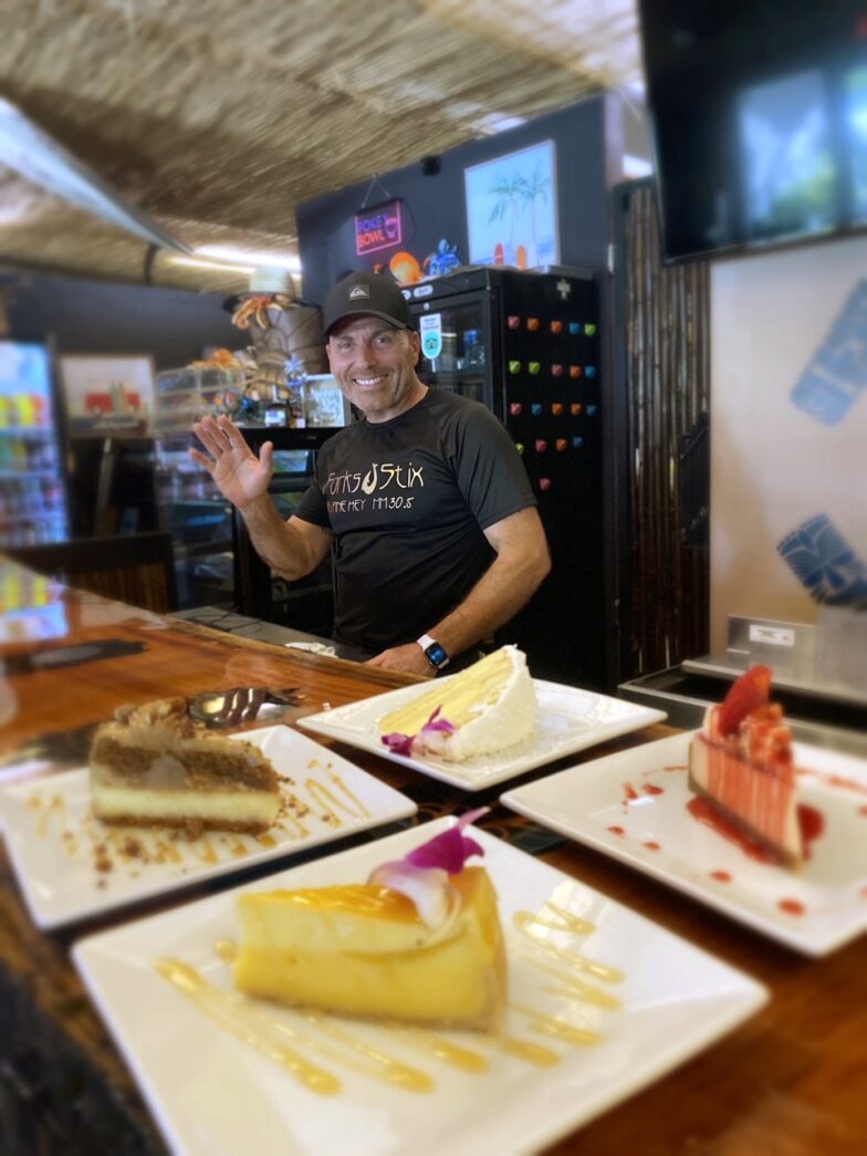 a man standing in front of a counter filled with desserts