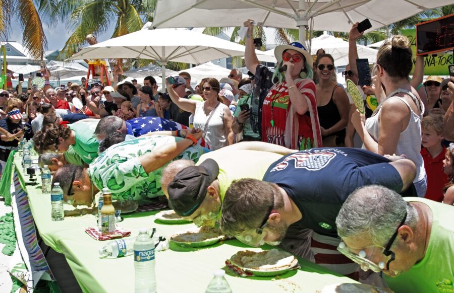 a group of people standing around a table covered in food