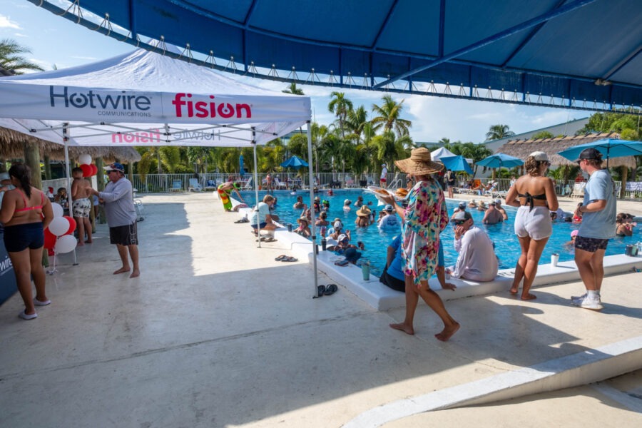 a group of people standing around a swimming pool