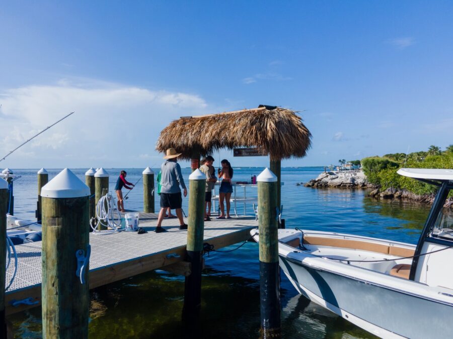 a group of people standing on a dock next to a boat