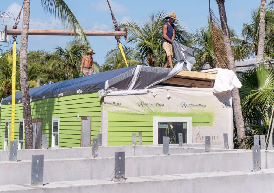 a couple of men standing on top of a green house