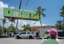 a woman taking a picture of a house under construction