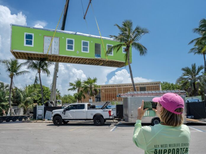 a woman taking a picture of a house under construction