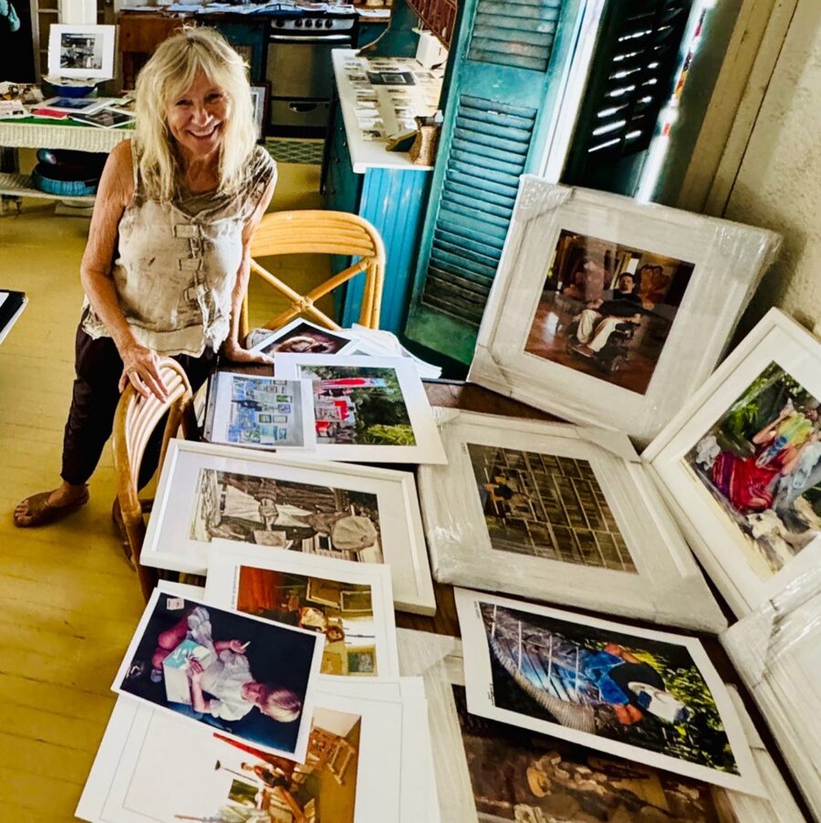 a woman standing next to a table filled with pictures