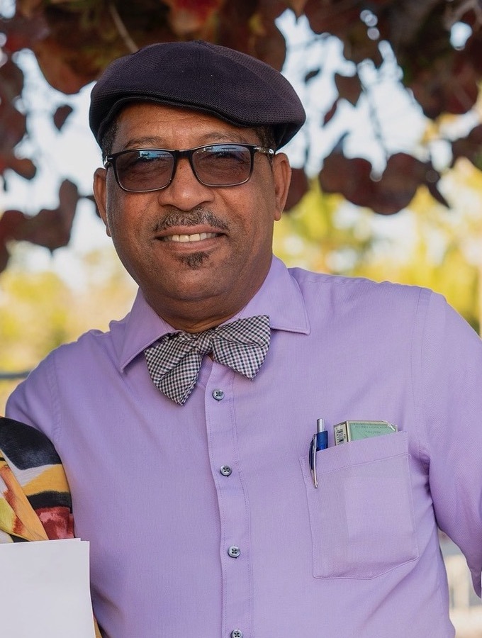 a man in a purple shirt holding a skateboard