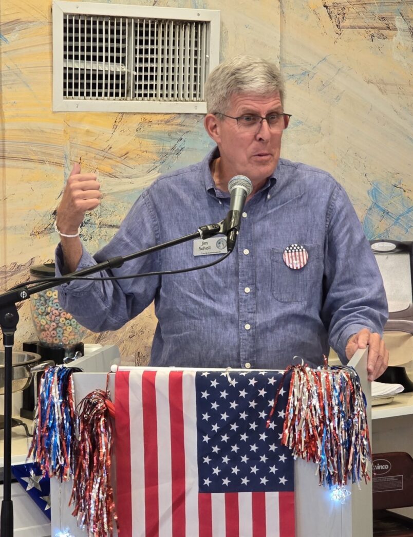 a man standing at a podium with an american flag on it