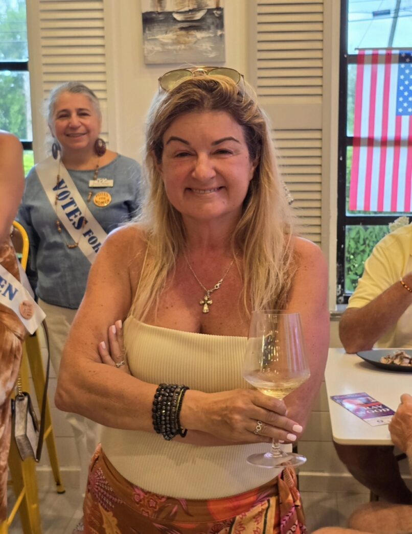 a woman in a skirt holding a glass of wine