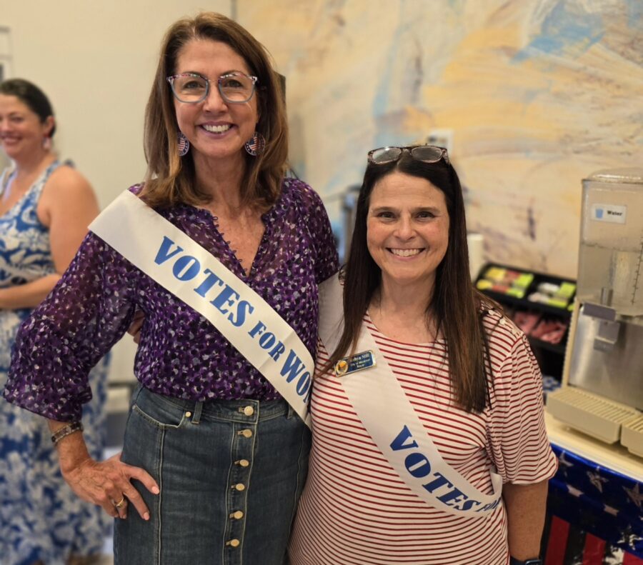 two women standing next to each other in a room