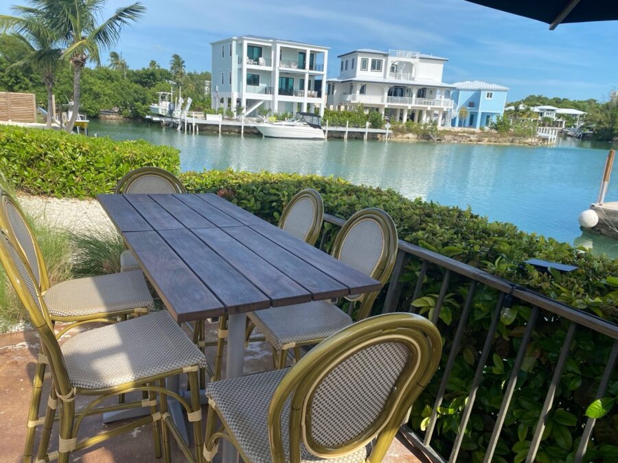 a table and chairs on a balcony overlooking a body of water