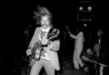 a black and white photo of a man playing a guitar