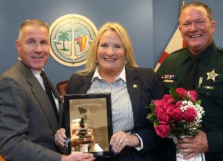 two men and a woman holding a framed picture