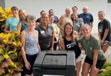 a group of people standing around a trash can