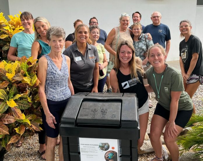 a group of people standing around a trash can