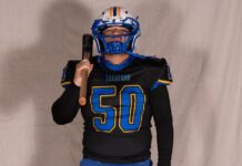 a man in a football uniform holding a baseball bat