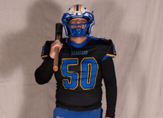 a man in a football uniform holding a baseball bat