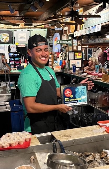 a man standing behind a counter in a restaurant