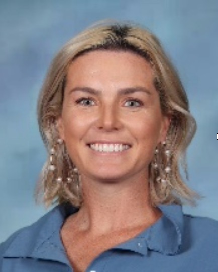 a woman wearing a blue shirt and earrings