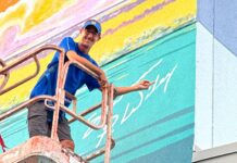 a man is painting a mural on the side of a building