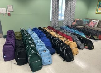 NAVY MORALE GROUP HOSTS BACK-TO-SCHOOL BASH & BACKPACK GIVEAWAY a man and a woman sitting in a chair in a living room
