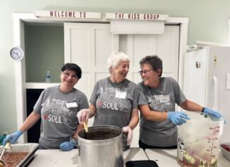 COOKING WITH LOVE NOURISHES IN MORE WAYS THAN ONE a group of people standing around a pot of food