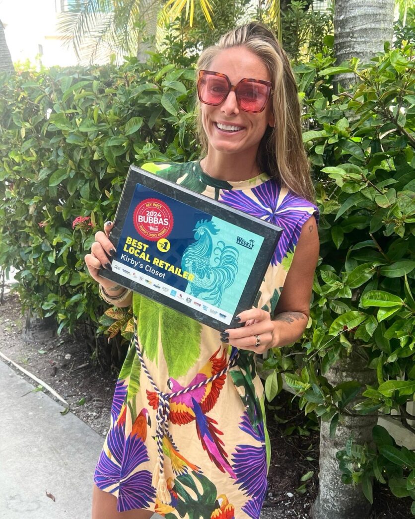 a woman in a colorful dress holding a framed picture