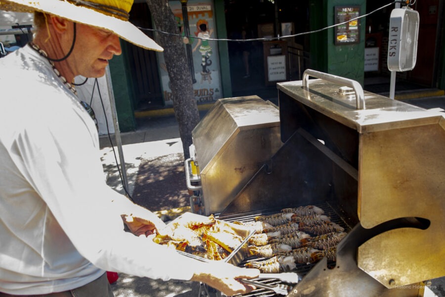 a man cooking food on a grill outside