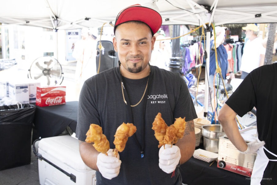 a couple of men standing next to each other holding food