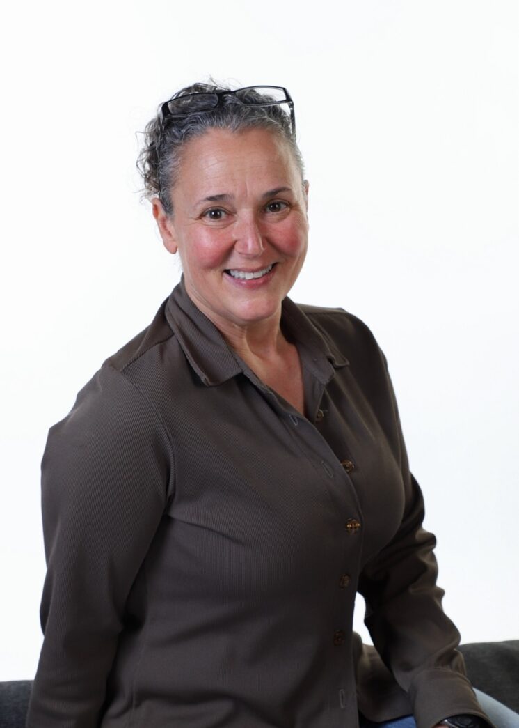 a woman sitting on a couch smiling for the camera