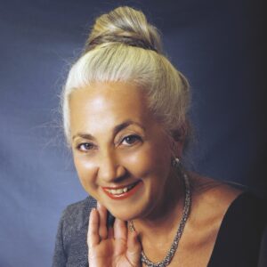 a woman with blonde hair wearing a black top