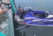 a blue and white jet ski sitting on top of a body of water