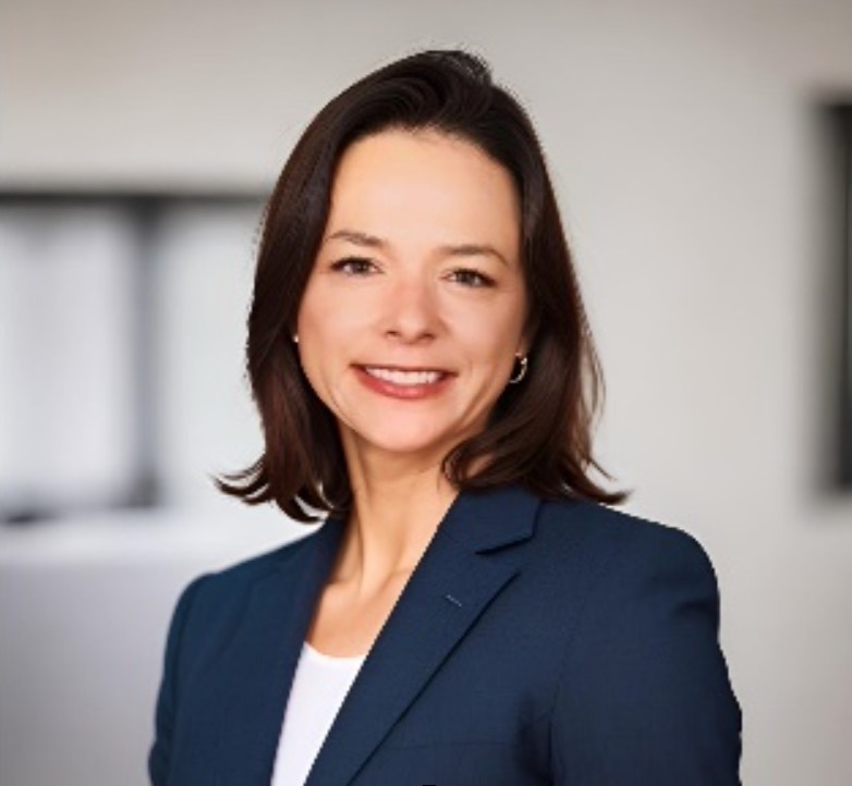 a woman in a business suit smiling for the camera