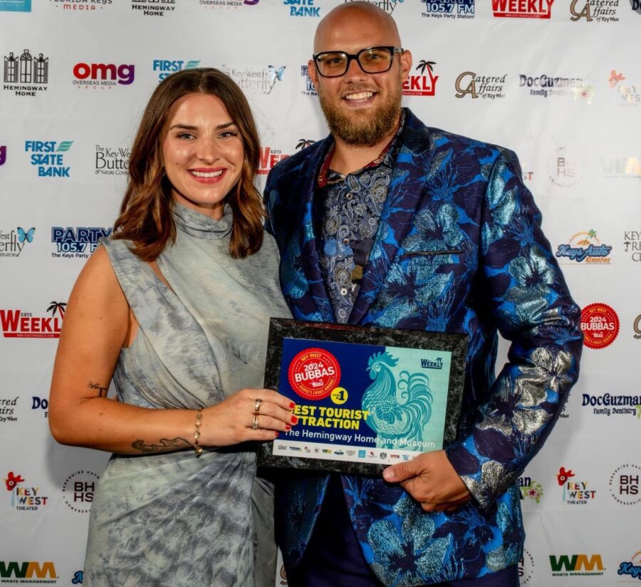 a man standing next to a woman holding an award