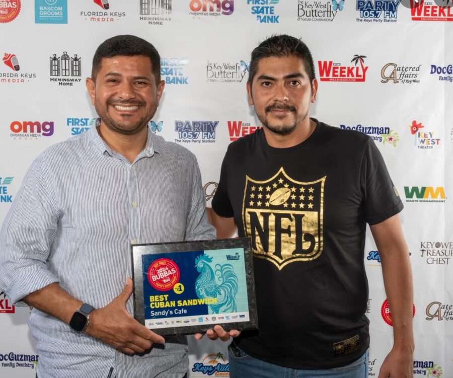 two men standing next to each other holding a plaque