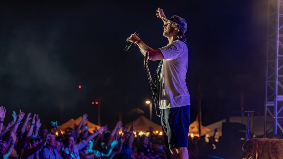 a man standing on top of a stage holding a microphone