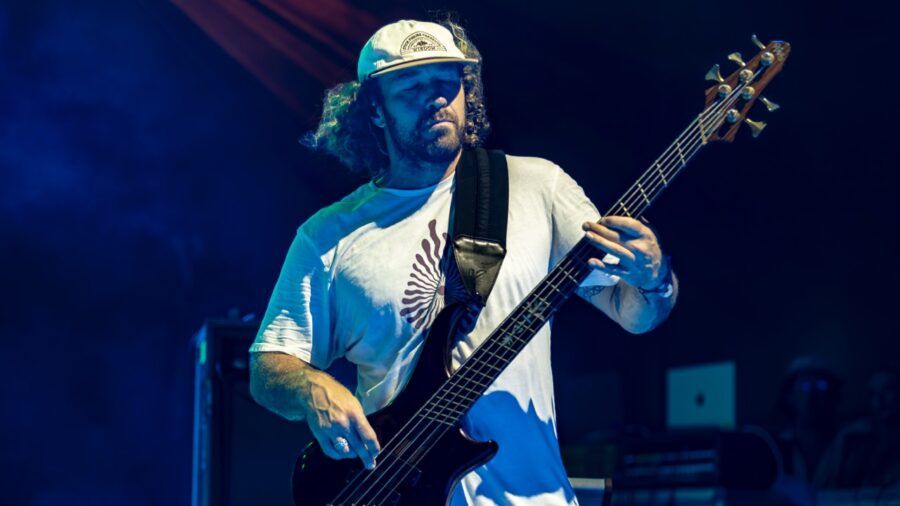 a man playing a bass guitar on stage