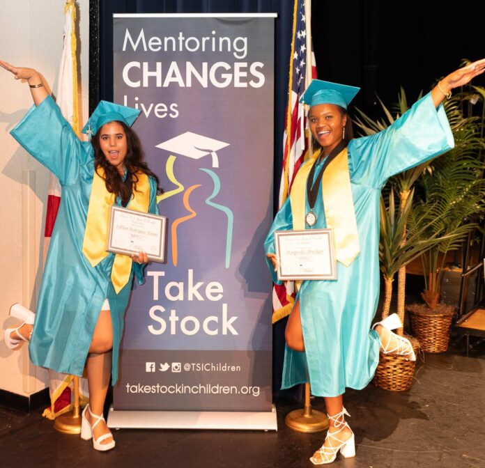 two women in graduation gowns posing for a picture