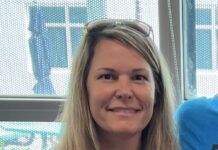 a woman with long blonde hair wearing a blue shirt