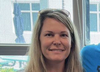 a woman with long blonde hair wearing a blue shirt